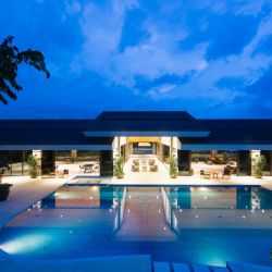blue body of water in front of building near trees during nighttime