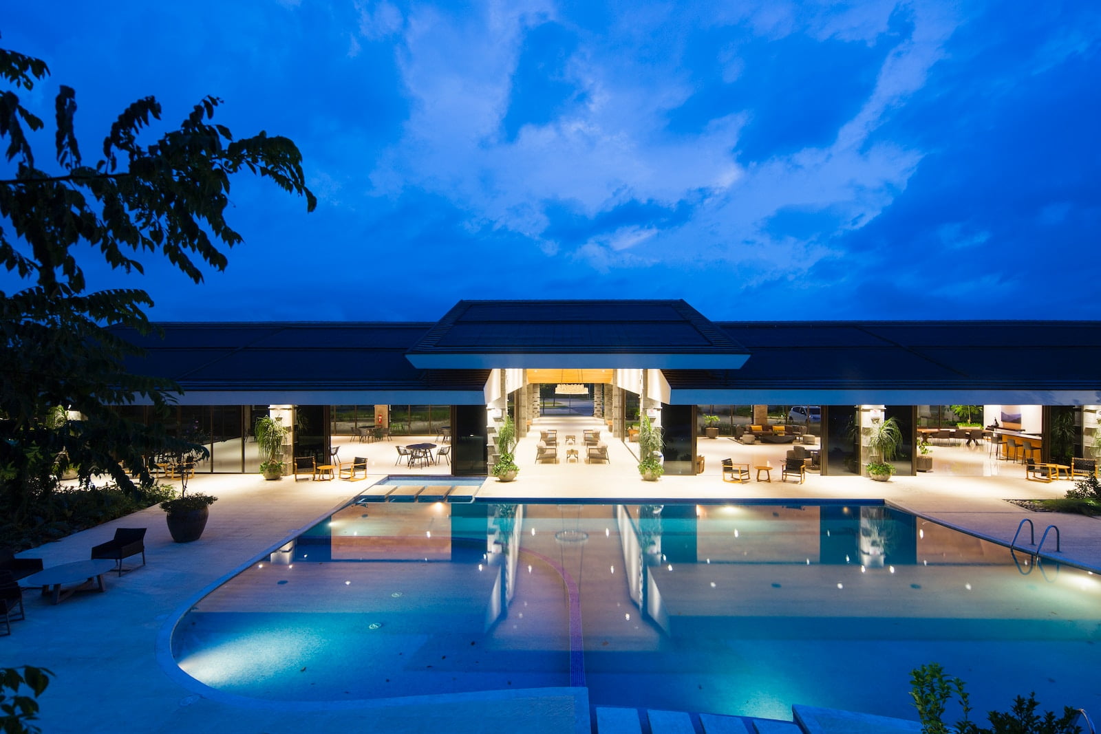 plan d'eau bleu devant un bâtiment près d'arbres pendant la nuit