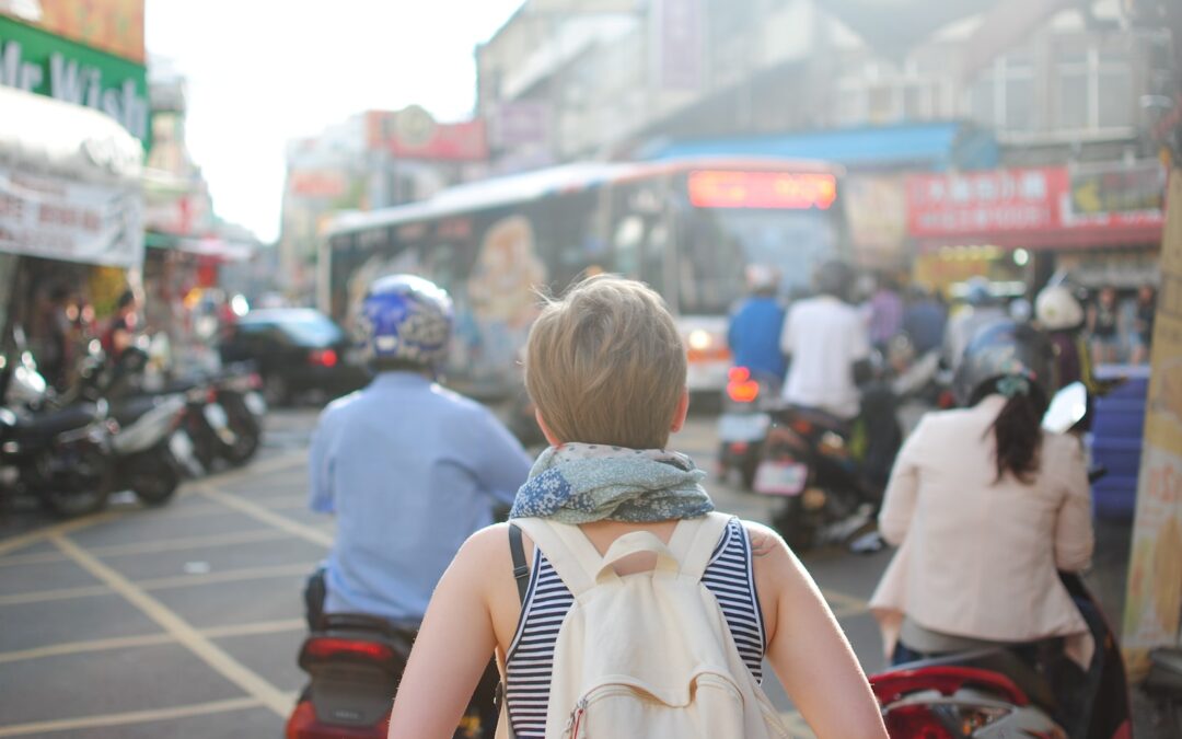 woman wearing backpack walking on road