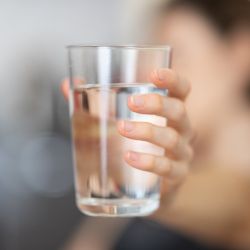 persona sosteniendo un vaso transparente
